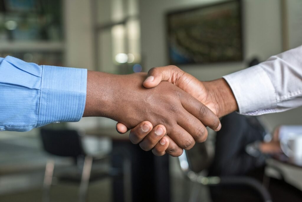 Main sujet: deux personnes se serrant la main dans un cadre professionnel, symbole de collaboration et de recrutement efficace. Inclut le mot-clé: comment recruter rapidement des travailleurs, intégré naturellement: "Serrage de main entre partenaires pour illustrer comment recruter rapidement des travailleurs".